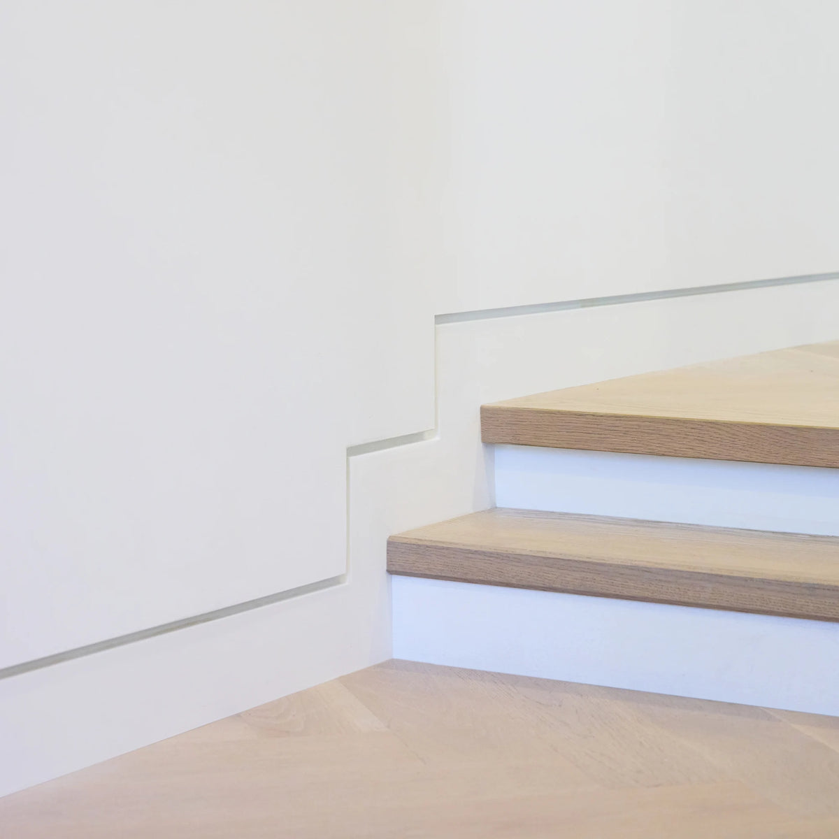 Shadow-line reveal detail where a recessed baseboard meets the drywall